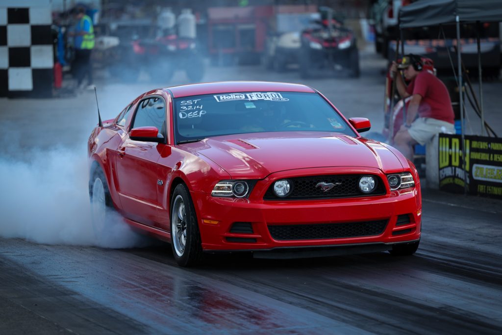 red late model ford mustang doing a burnout