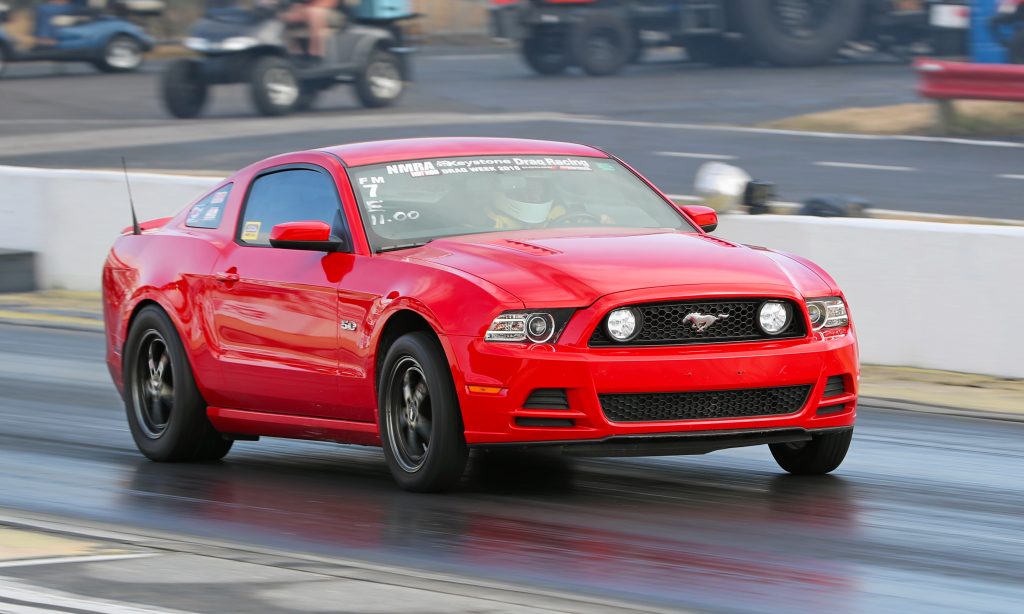 red mustang coyote on dragstrip