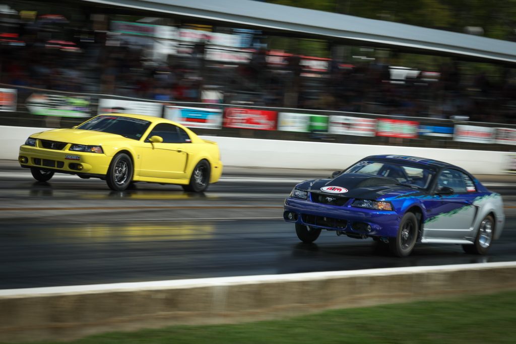 a pair of new edge ford mustangs on dragstrip