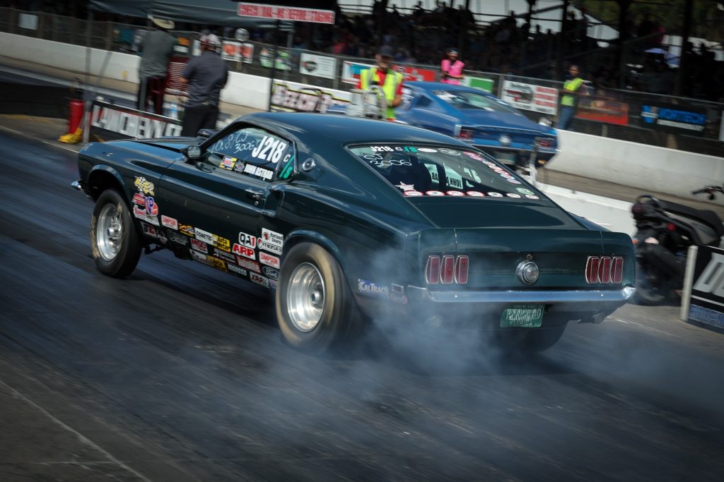 1969 Ford Mustang doing a burnout at the track