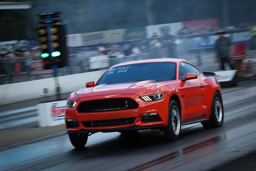 red late model ford mustang drag car launching at track