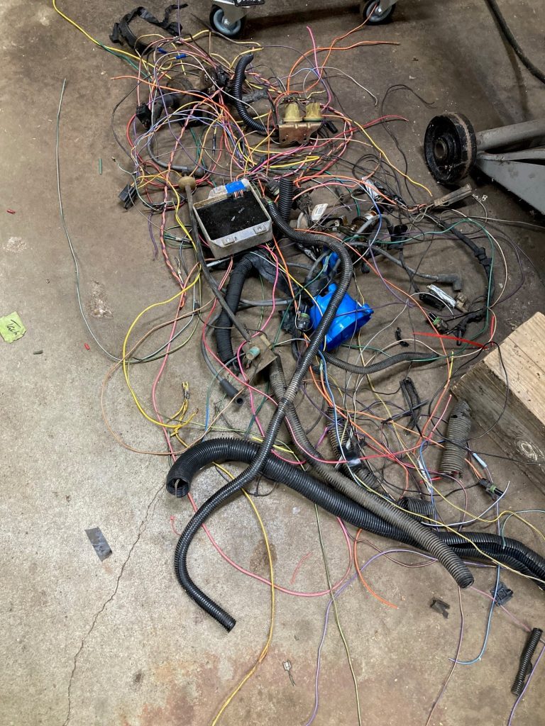 Old vehicle wiring harness discarded onto floor