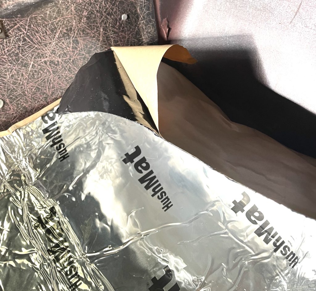 Peeling backing paper from HushMat floor insulation