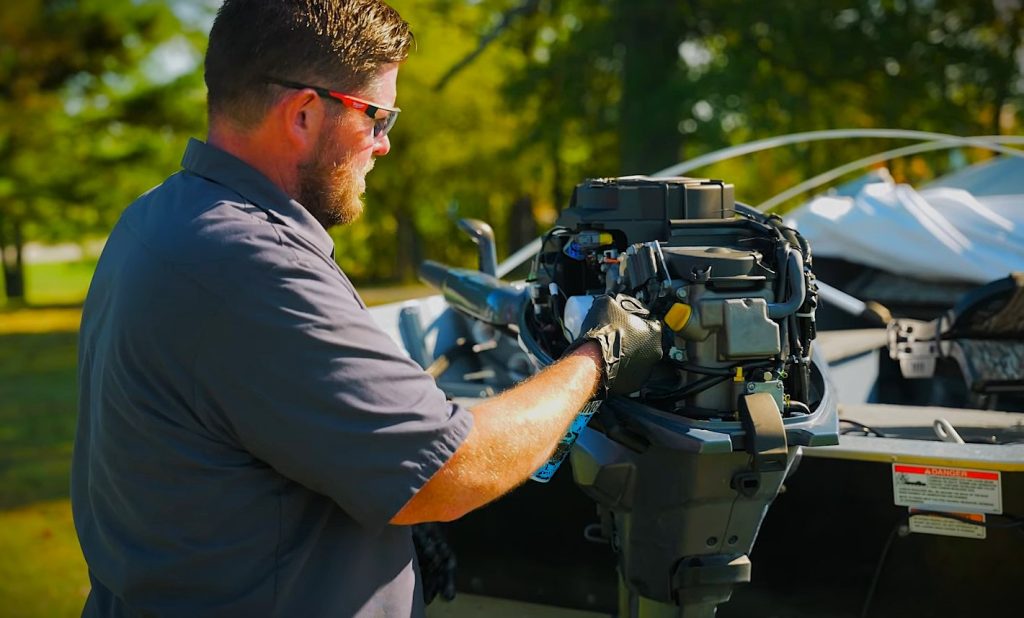 man spraying fogging oil into a boat engine
