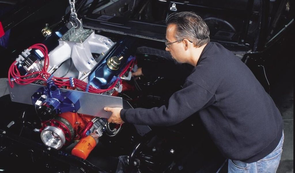 man leaning over an engine bay during install