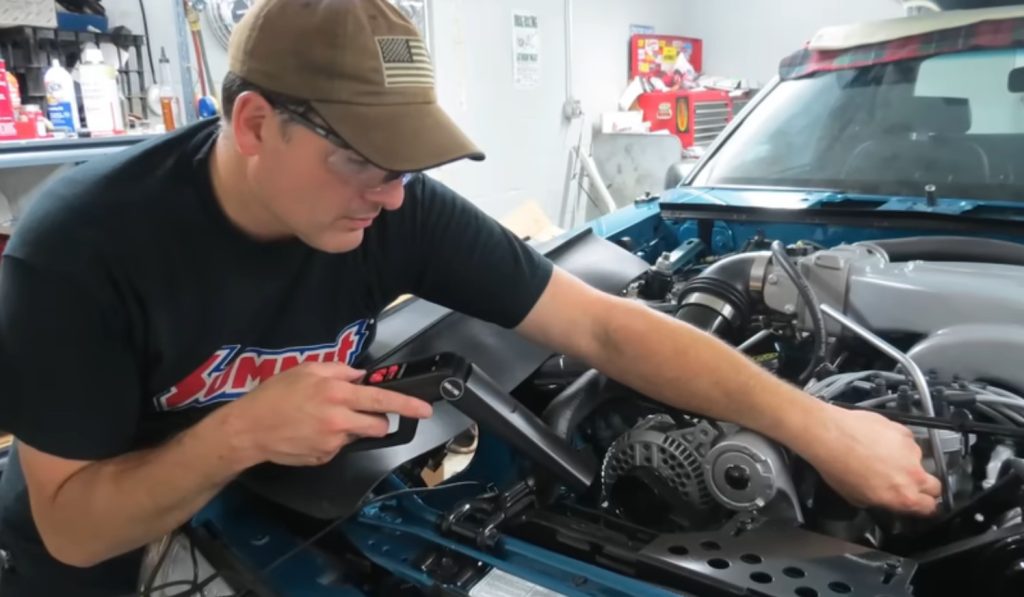 man checking ignition timing on an engine