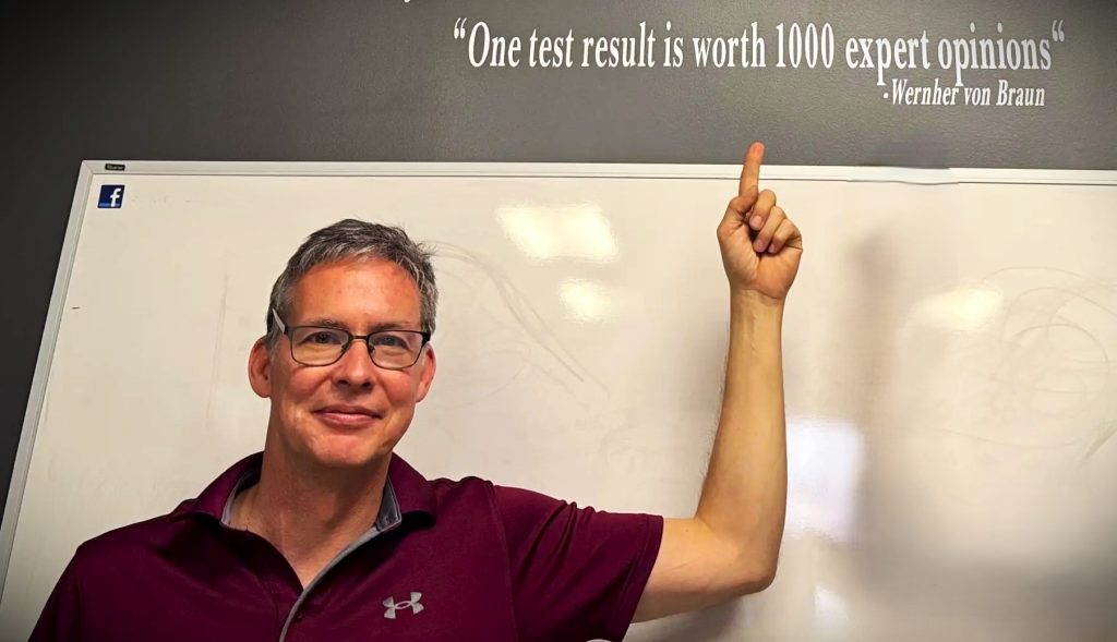 man pointing to quote on sign