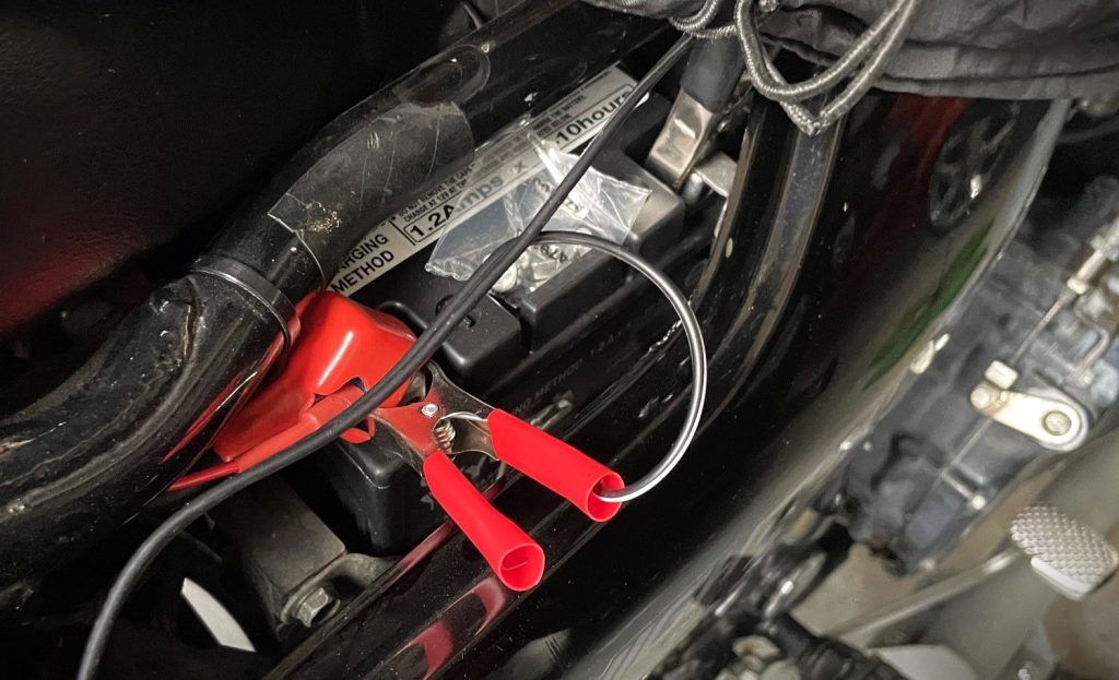 large alligator clips on a vehicle battery