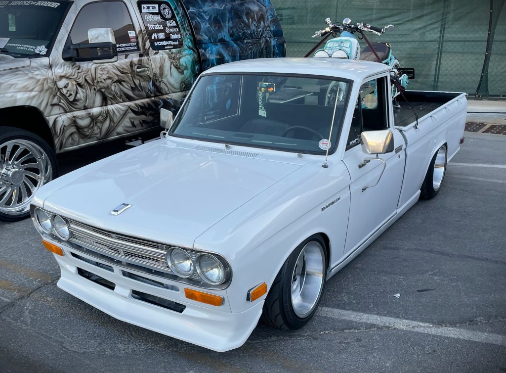 vintage datsun pickup truck with honda ruckus in bed
