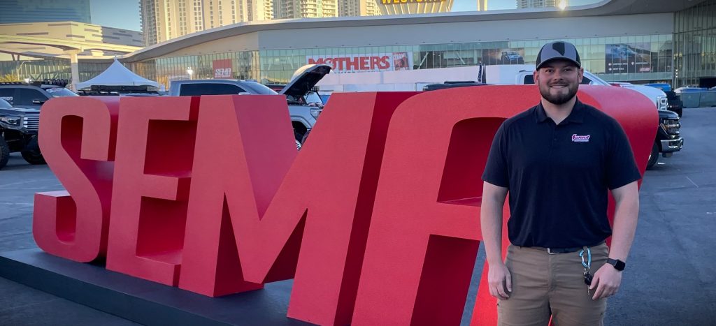 man standing in front of SEMA Sign