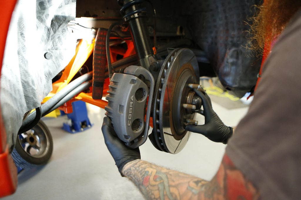 man installing a brake caliper