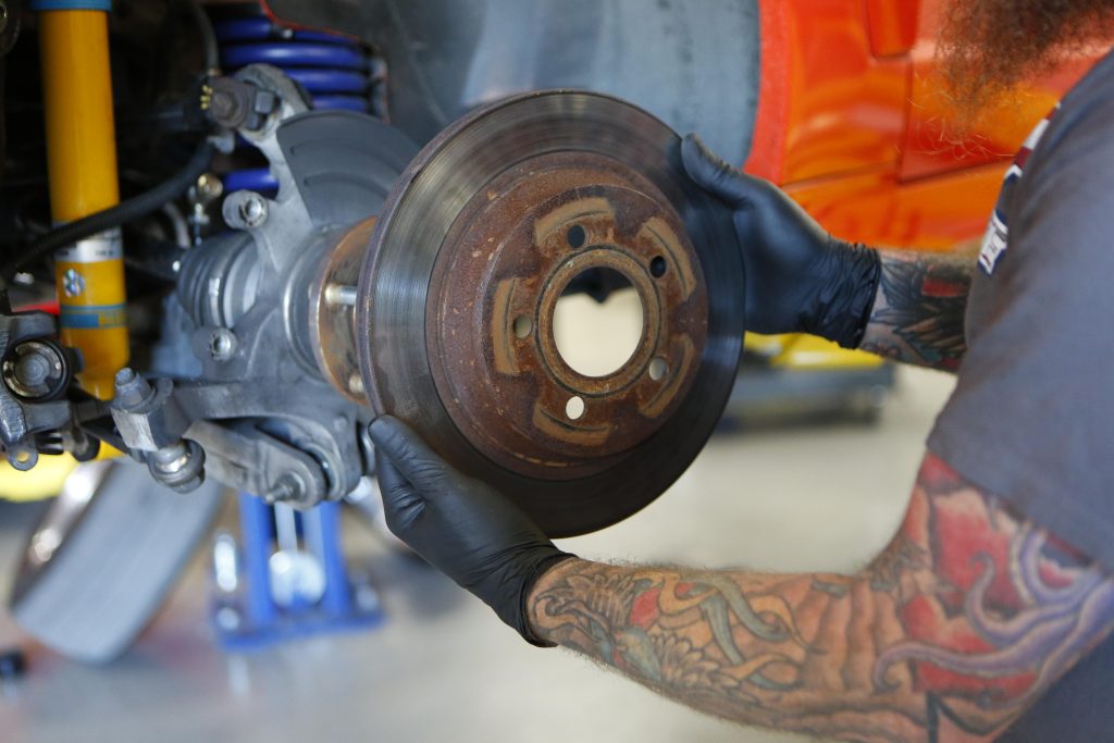 man removing an old used brake rotor