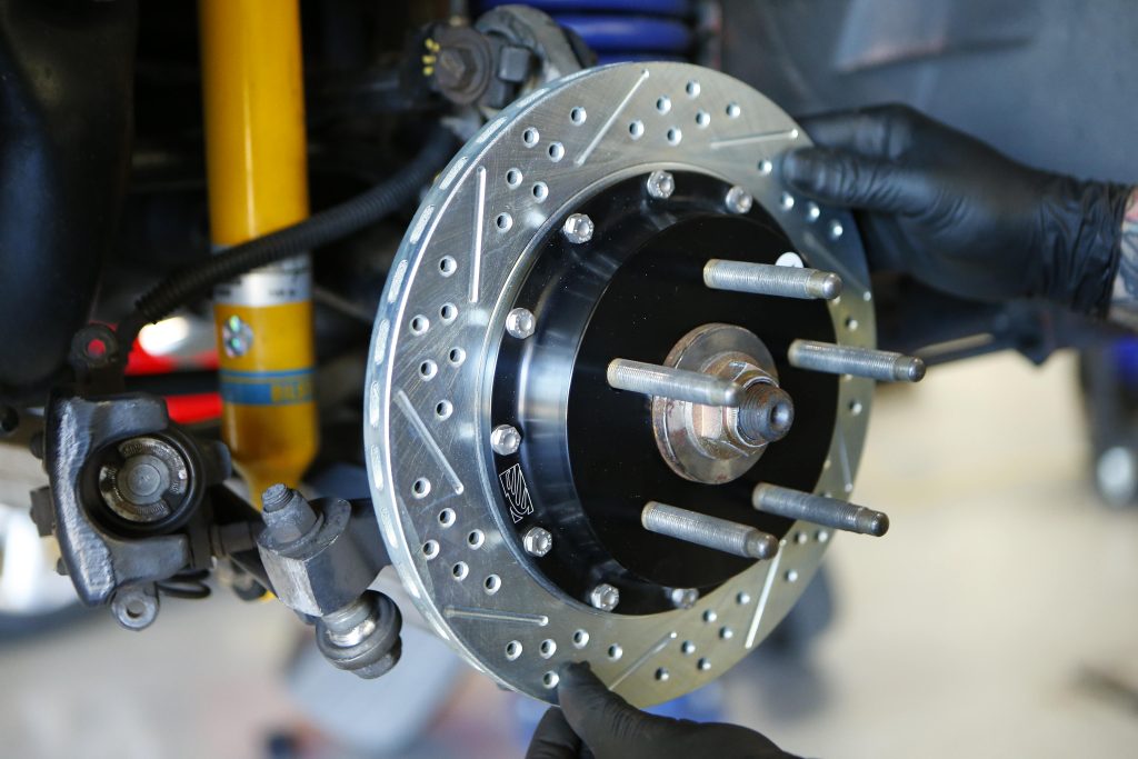 man fitting a baer brake rotor onto a hub
