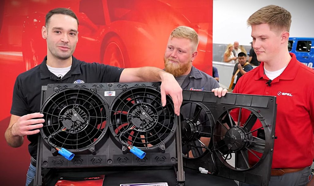 men in trade show booth with electric fans