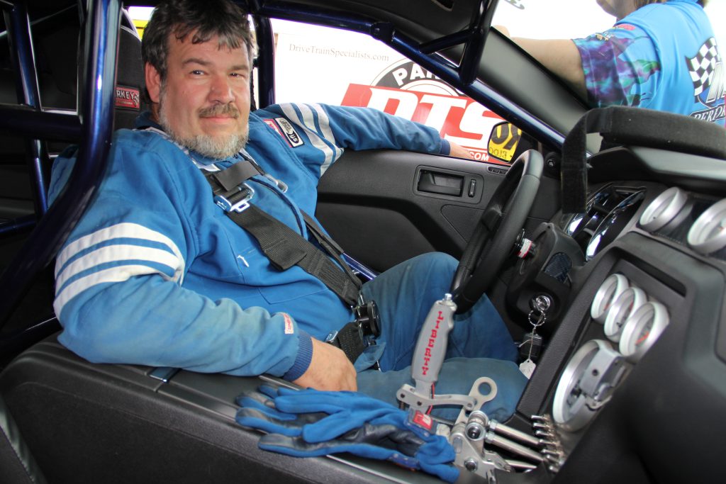 driver sitting in cockpit of race car