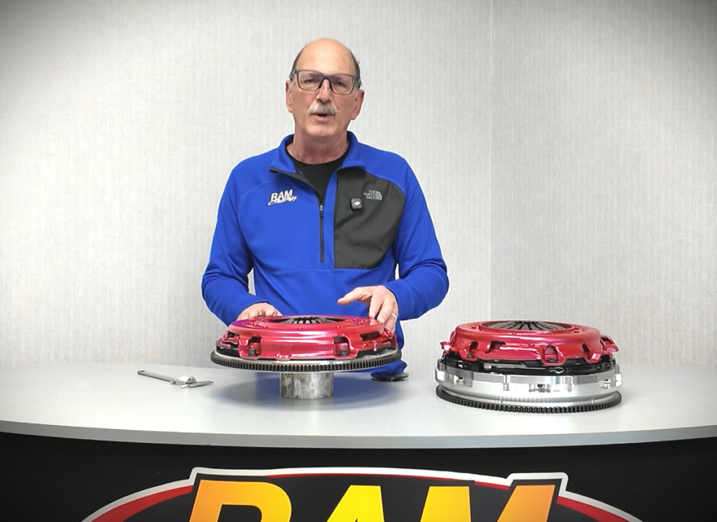 man speaking behind a clutch display table