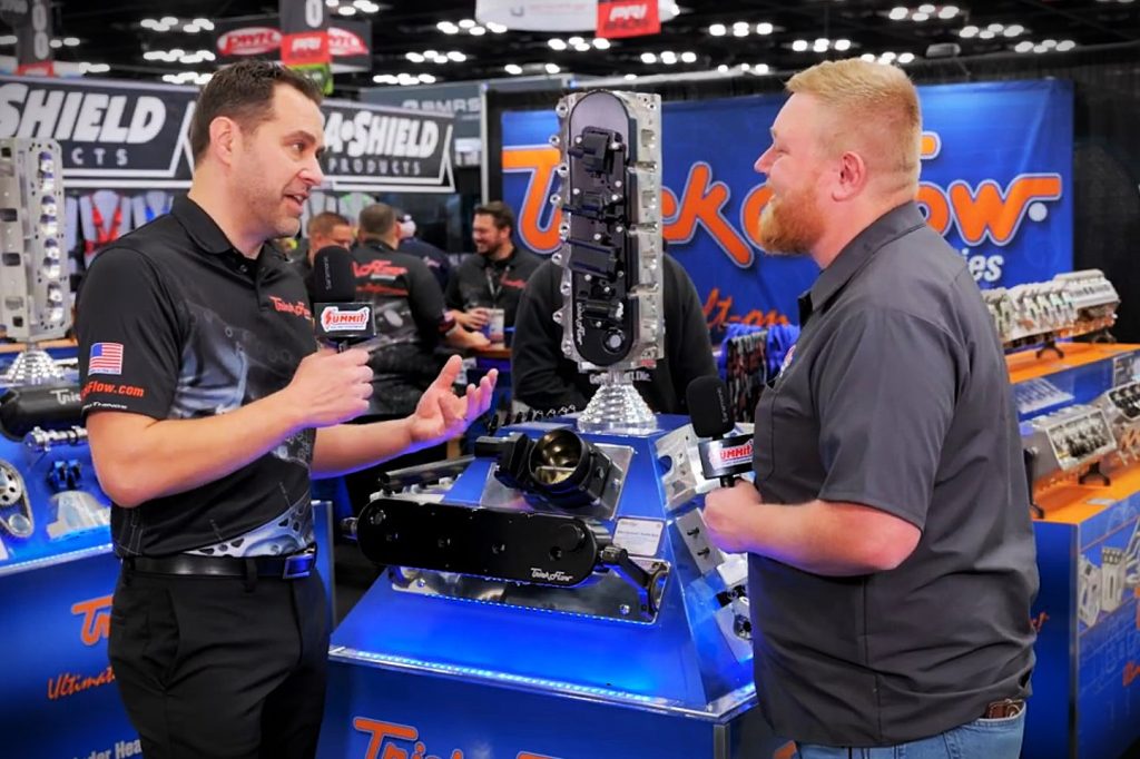 man being interviewed in a trade show engine display booth